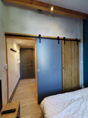 a blue sliding door in a room with a bed at Studio 2 personnes in Le Mont-Dore