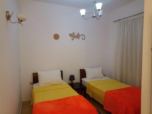 Habitación con 2 camas con sábanas coloridas. en South marina apartment MS10 Wi-Fi available en Hurghada