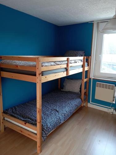 Ce lit se trouve dans un dortoir doté de 2 lits superposés et d'un mur bleu. dans l'établissement Maison familiale au Chenal, à Grand-Fort-Philippe