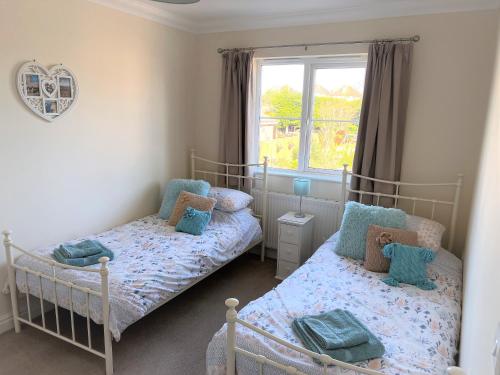 a bedroom with two beds and a window at 2 Brunswick Terrace in Sandown