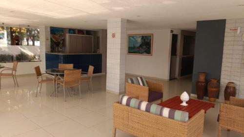 een woonkamer met een tafel en stoelen bij Praia dos Carneiros Flat Hotel Lindo Apto 302 in Praia dos Carneiros