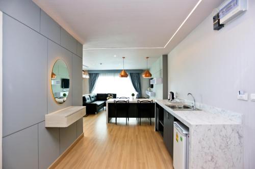 a kitchen and living room with a sink and a table at Le Breeze Resort Hua hin in Cha Am