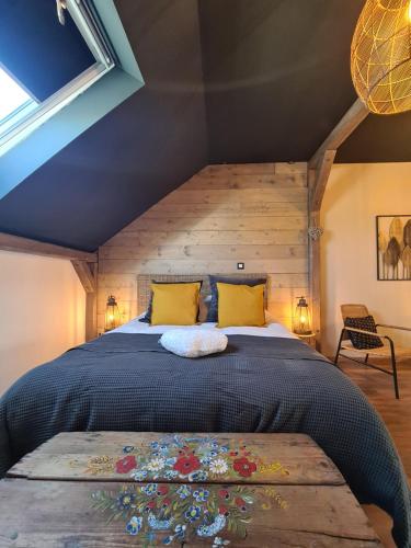 ein Schlafzimmer mit einem großen Bett mit gelben Kissen in der Unterkunft La suite Mélusine - SPA du Souffle du Saule in Buhl-Lorraine