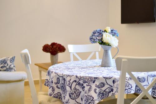 a table with a blue and white table cloth and flowers on it at R Cottage Jacuzzival in Balatonfenyves