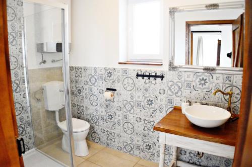 e bagno con servizi igienici, lavandino e doccia. di R Cottage Jacuzzival a Balatonfenyves