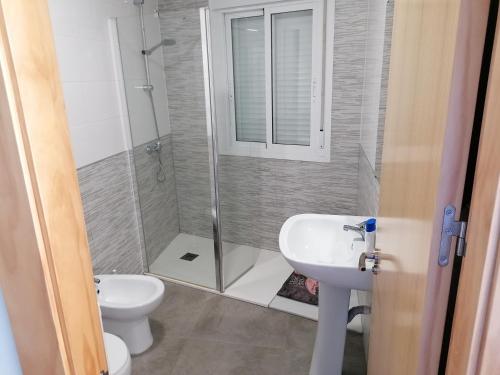 een badkamer met een douche, een toilet en een wastafel bij Alojamiento las Dunas alto in Tabernas