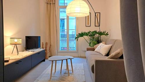 ein Wohnzimmer mit einem Sofa und einem TV in der Unterkunft Grand Studio Luxe in Sète