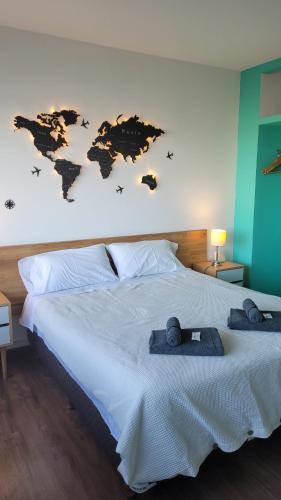a bedroom with a large bed with a world map on the wall at Bariloche Studio Center Leg.1068 in San Carlos de Bariloche
