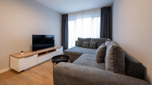 a living room with a couch and a flat screen tv at Hotel Metropol in Tübingen