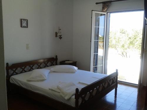 a bedroom with a bed and a large window at Wind Villas Pounda in Pounda