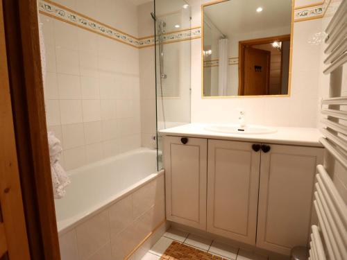 une salle de bain avec une baignoire, un lavabo et un miroir dans l'établissement Appartement confortable pour 6 avec balcon et parking aux Gets - FR-1-623-120, aux Gets