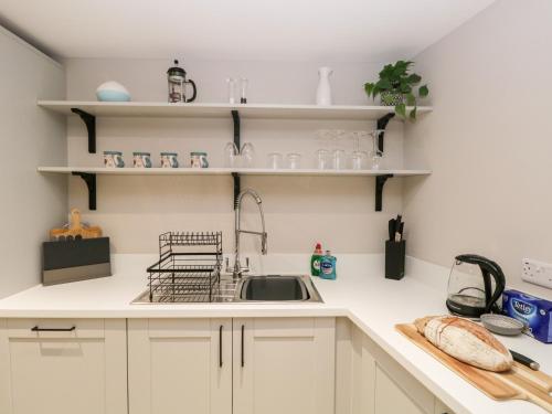 a kitchen with white cabinets and a sink at Grizedale in Kendal