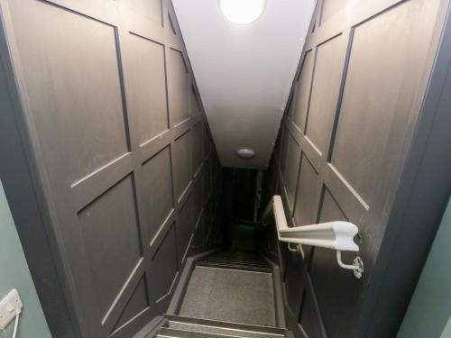 a hallway with a door and a staircase with a toilet at Grizedale in Kendal