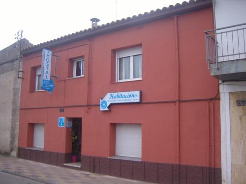 un edificio rojo con un letrero. en Hostal Cassa, en Cassá de la Selva