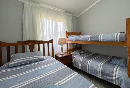 a bedroom with two bunk beds and a window at Voelroepersfontein in Albertinia