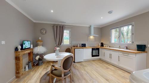 a kitchen with a table and chairs in a room at Gîte Spa & Nature in Saint-Chamassy