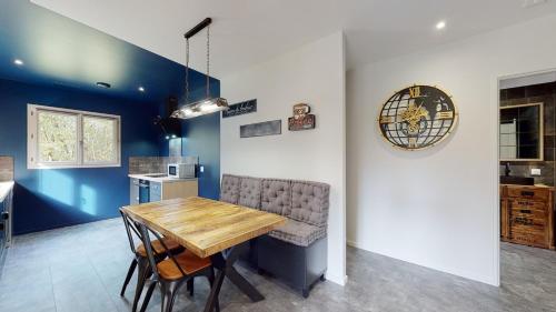 a dining room with a table and a clock on the wall at Gîte Spa & Nature in Saint-Chamassy