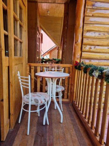 un porche con mesa y sillas en Elfen hospedaje familiar, en Oxapampa
