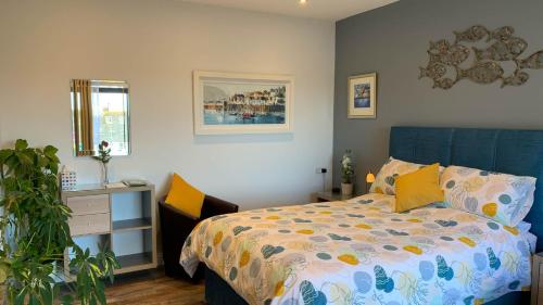 Un dormitorio con una cama y una planta. en Portmellon Cove Guest House, en Mevagissey