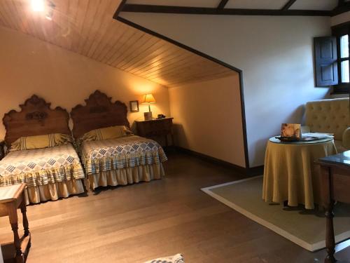 a bedroom with two beds and a table at Palacio de Cutre in La Goleta