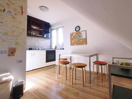 a kitchen with a table and four stools at Hostel Mamas & Papas in Gdańsk