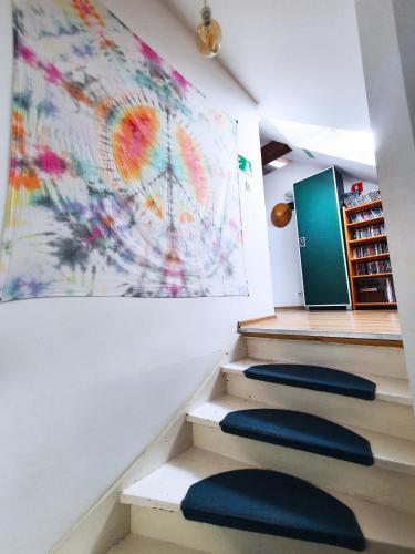 a staircase with three blue stools and a painting at Hostel Mamas & Papas in Gdańsk