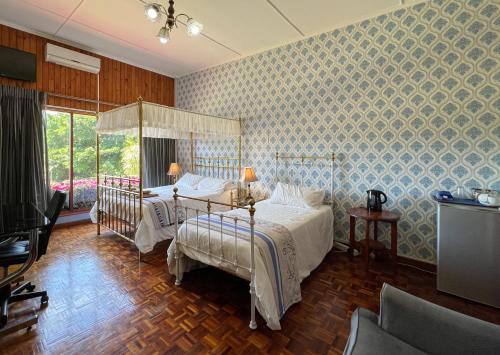 a bedroom with two beds and a tv at Voelroepersfontein in Albertinia