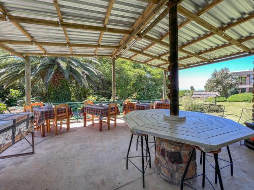 a patio with a table and chairs under a roof at Voelroepersfontein in Albertinia