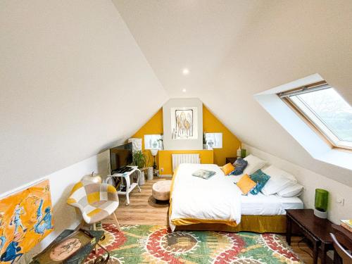a attic bedroom with a bed and a window at CHAMBRE APPARTEMENT in Roscoff