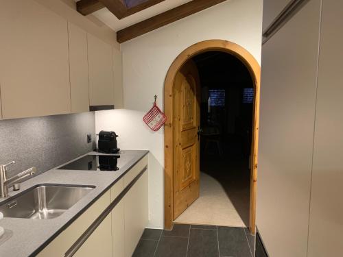 eine Küche mit einem Waschbecken und einer Holztür in der Unterkunft Chesa La Furia in Pontresina