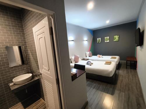 a hotel room with two beds and a toilet at Aen Guy Boutique Hotel in Sukhothai