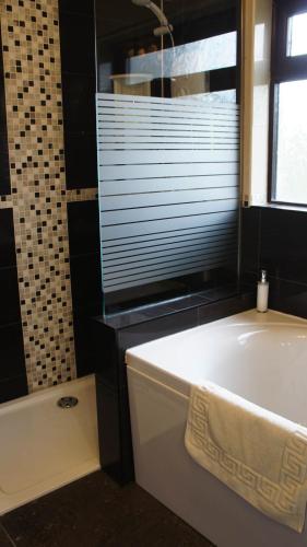 a bath tub in a bathroom with a window and a tub at Portmellon Cove Guest House in Mevagissey
