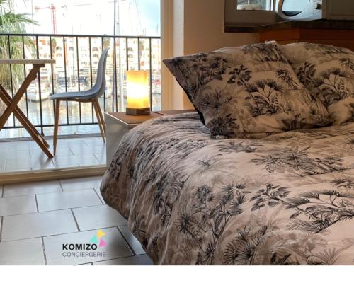 une chambre avec un lit, une table et une chaise dans l'établissement La Brise Marine. Vue Panoramique Port de Plaisance, à Leucate