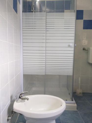 a bathroom with a shower and a white sink at Villetta panoramica con vista mare in Carloforte