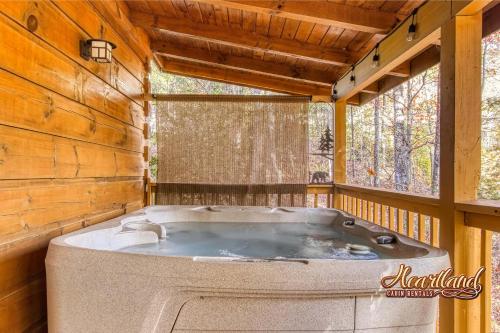 eine Whirlpool-Badewanne in einer Hütte mit Fenster in der Unterkunft Beary Lazy in Sevierville