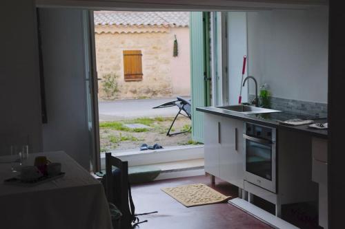 a kitchen with a counter and a sink and a window at Studio tout confort dans maison de caractère in La Bastide