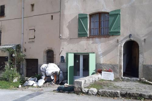a building with a green door in front of it at Studio tout confort dans maison de caractère in La Bastide