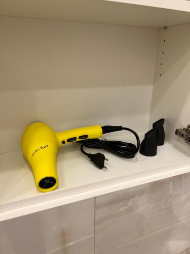 a yellow blow dryer sitting on a shelf at Old town apartment in Kaunas