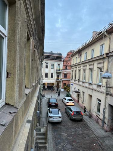 a group of cars parked on a street with buildings at Old town apartment in Kaunas