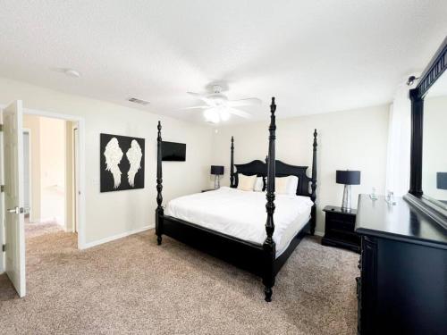 um quarto com uma cama e uma televisão em Resort Home, Private Pool Orlando Disney sleeps12 em Kissimmee