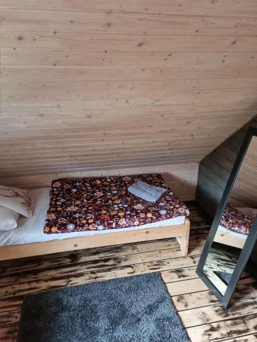a bed in a room with a wooden wall at Ostoja Karkonoska in Podgórzyn