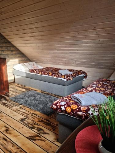 two beds in a room with wooden floors at Ostoja Karkonoska in Podgórzyn