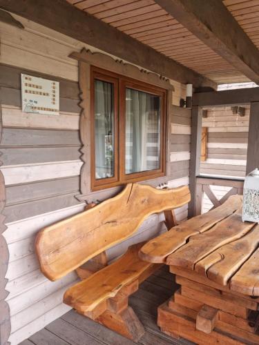 a wooden bench on the side of a cabin at Ostoja Karkonoska in Podgórzyn