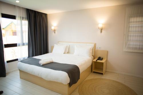 a bedroom with a bed and a large window at Flora Hotel Ivato International Airport in Antananarivo