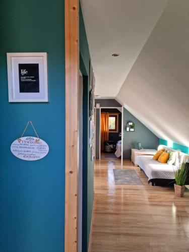 a bedroom with a bed and a blue wall at Ostoja Karkonoska in Podgórzyn