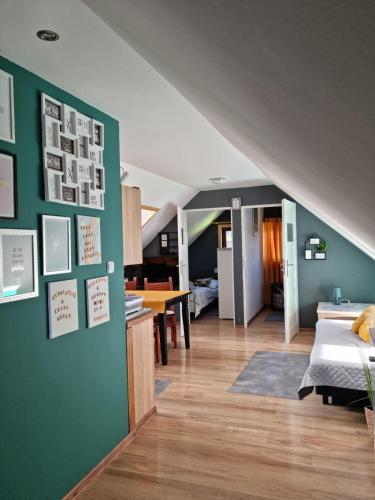 a living room with a green accent wall and a kitchen at Ostoja Karkonoska in Podgórzyn