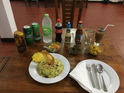a table with two plates of food and drinks at BAWANS VILLA Holiday Home for Family or Group in Hikkaduwa