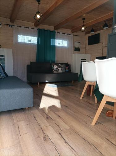a living room with a couch and two white chairs at Ostoja Karkonoska in Podgórzyn