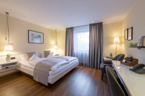 a hotel room with a bed and a desk at Hotel Deutscher Hof in Trier