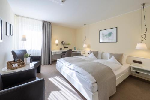 a hotel room with a large bed and a desk at Hotel Deutscher Hof in Trier